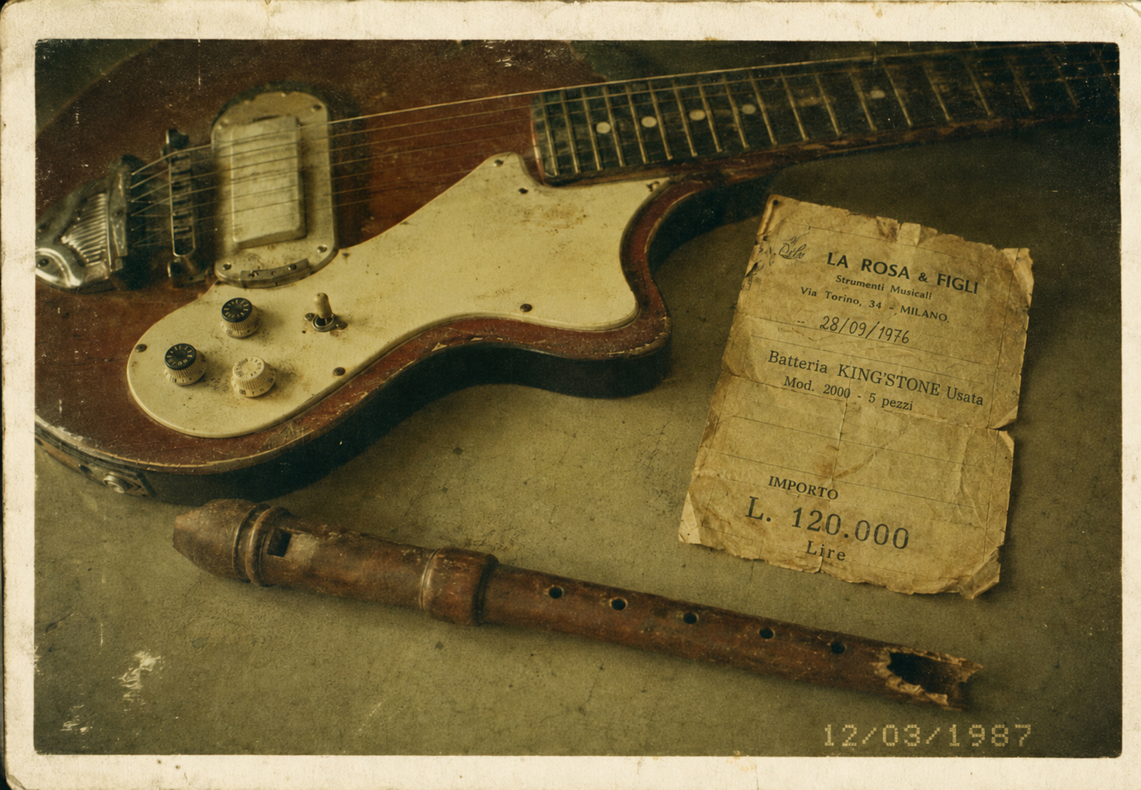 Natura morta del 12 marzo 1987: una chitarra Eko, un flauto dolce, una ricevuta d'acquisto.
